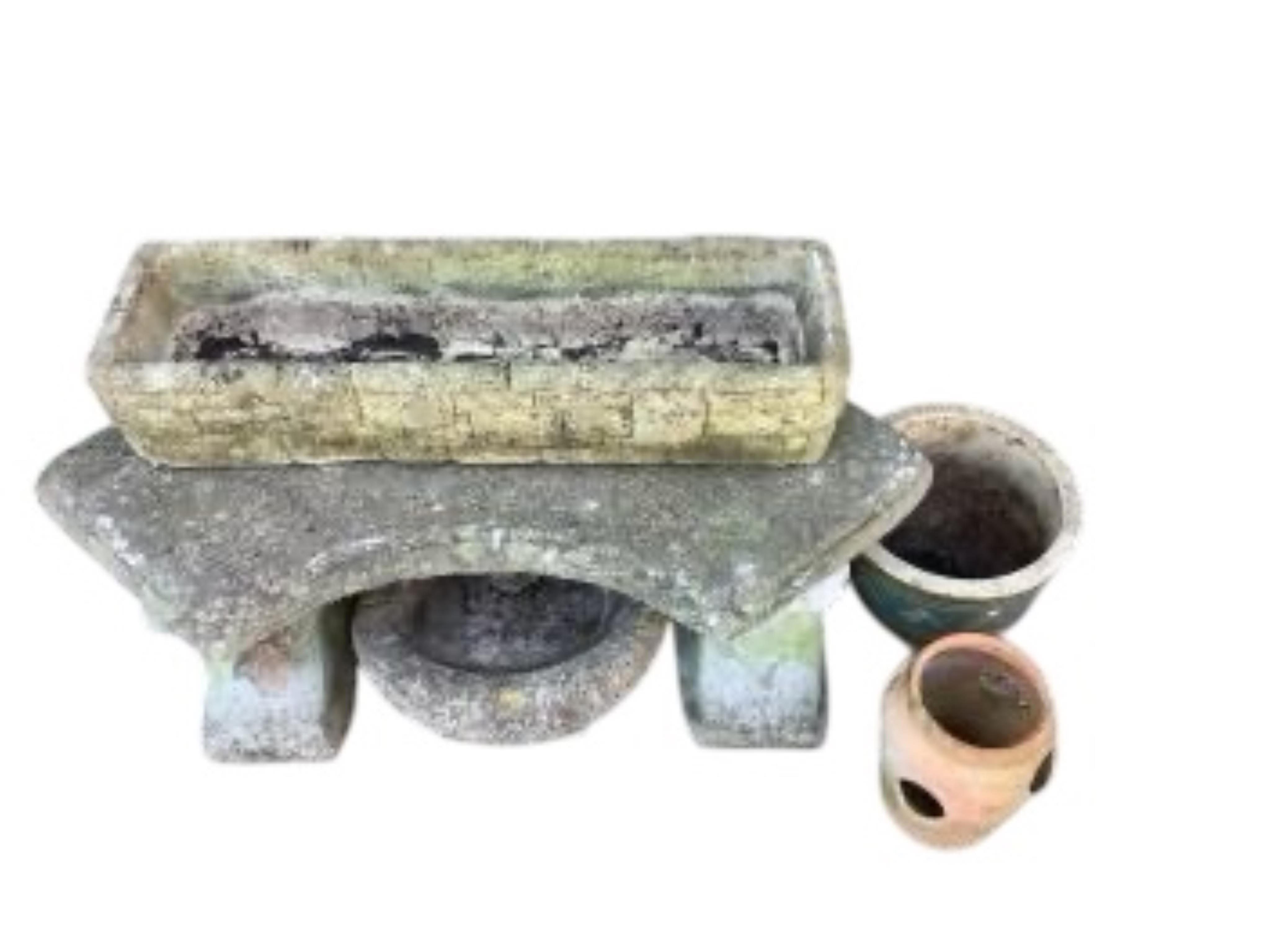 A curved reconstituted stone garden bench, length 102cm, together with three planters and a bird bath